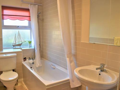a bathroom with a sink and a toilet and a window at Beautiful Cottage In Alnwick With 2 Bedrooms And Wifi in Alnwick