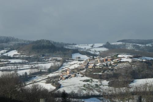 a village on a hill covered in snow at Hôtel Restaurant Le Moulin de Saint Verand in Saint-Vérand