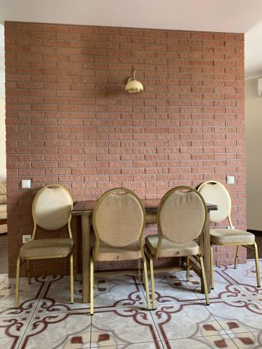 four chairs around a table in front of a brick wall at Great apartment in the city centre in Ivano-Frankivsʼk