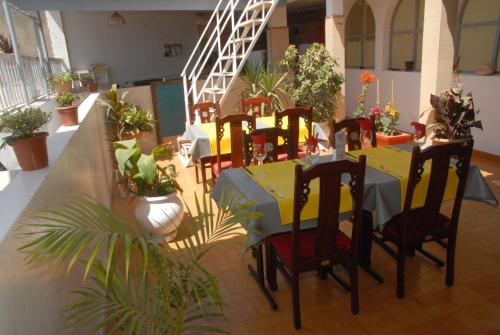 a dining room with a table and chairs and plants at Maison d'hôtes Opanoramic in Dakar