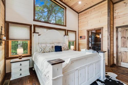 um quarto com uma grande cama branca e janelas em Grizzly Cabin em McCaysville