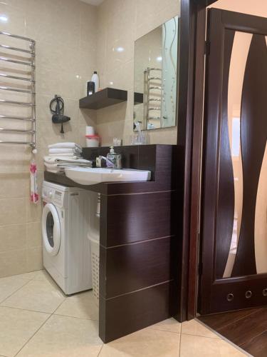 y baño con lavabo y lavadora. en Great apartment in the city centre, en Ivano-Frankivsk