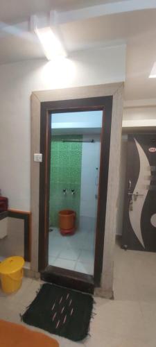 a bathroom with a mirror and a toilet in a room at Sai Raghunandan Guest House in Shirdi