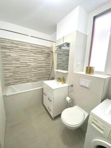 a bathroom with a toilet and a sink and a tub at Golden Penthouse Rebreanu Residence in Timişoara