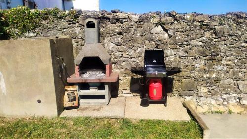 a brick wall with a grill and a fire hydrant at Maison confortable à Bardos avec vue sur montagne in Bardos