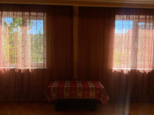 sypialnia z 2 oknami i łóżkiem w obiekcie Rural Treasure w Garni