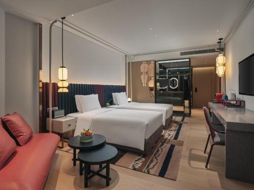 um quarto de hotel com uma cama grande e um sofá em Hotel Indigo Hangzhou Uptown,Close to Westlake , boutique design hotel with freeflow minibar em Hangzhou