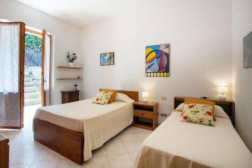 a bedroom with two beds and a window at Casa Marcella in Gaiole in Chianti