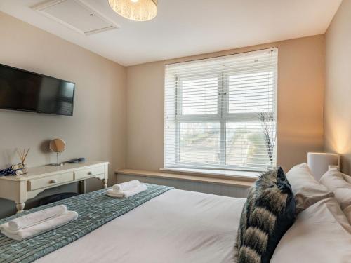 a bedroom with a bed with a television and a desk at The Perch-uk37325 in Cromer