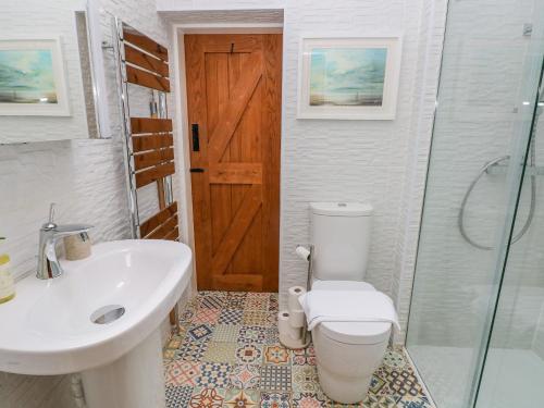 een badkamer met een toilet, een wastafel en een douche bij Lower Sketty Green Lodge in Swansea