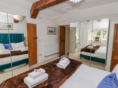 een slaapkamer met 2 bedden en een spiegel bij Lower Sketty Green Lodge in Swansea