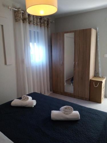 a bedroom with two towels on a bed with a mirror at La casa di Elen in Plati