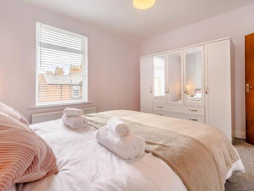 a bedroom with towels on a bed with a window at To Be in Scarborough