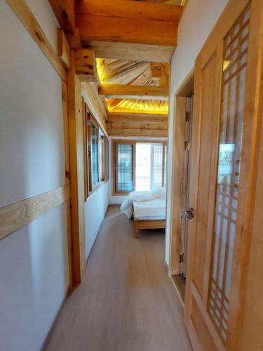 a hallway of a room with a bed and windows at Gyeongju Hanok Sohwa in Gyeongju