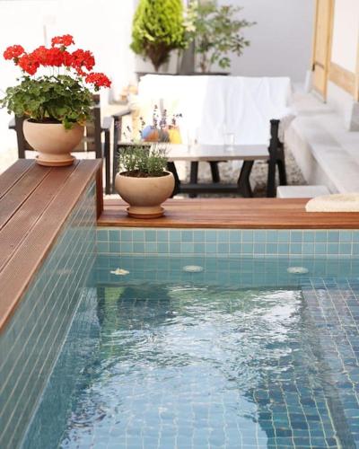 a swimming pool with two vases on a table with flowers at Gyeongju Hanok Sohwa in Gyeongju