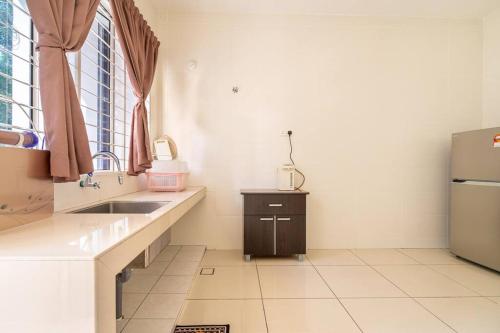 a kitchen with a sink and a refrigerator at COCONUT HOMESTAY Tanjong Karang Sekinchan Kuala Selangor in Kampong Sungai Kajang