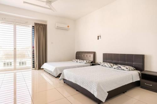 two beds in a bedroom with white walls at COCONUT HOMESTAY Tanjong Karang Sekinchan Kuala Selangor in Kampong Sungai Kajang