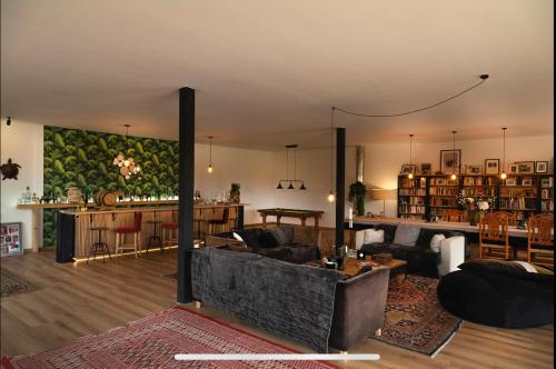 sala de estar con sofá, mesa y cocina en "Le Val des Prés" Atypique, Chambres spacieuses dans ancienne usine, 