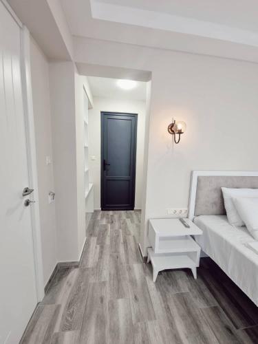 a white room with a bed and a black door at Picasso in Shekvetili