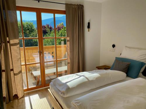 - une chambre avec un lit et une vue sur un balcon dans l'établissement Bergelemente - Bergahorn, à Schönau am Königssee