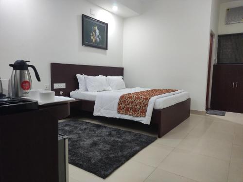 a hotel room with a bed and a desk and a bed sidx sidx at Harekrishna Hotel & Restaurant in Bhubaneshwar
