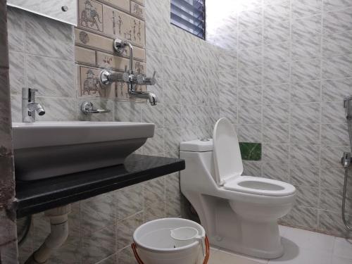 een badkamer met een toilet en een wastafel bij Harekrishna Hotel & Restaurant in Bhubaneshwar