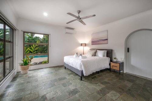 a bedroom with a bed and a ceiling fan at Talpa Tropix- 5 min stroll to beach in Palm Cove