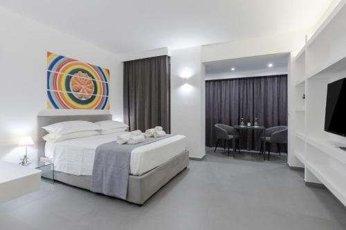 パレルモにあるSuite Palermo Apartmentのベッドとダイニングルームが備わるホテルルームです。