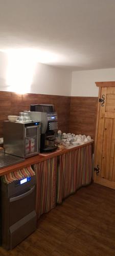 a kitchen with a counter with a microwave on it at Fattoria Meneguto Agriturismo Degasper Giorgio in Cortina dʼAmpezzo