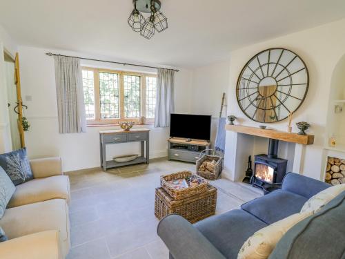 a living room with a couch and a fireplace at Blossom Cottage in Broadway