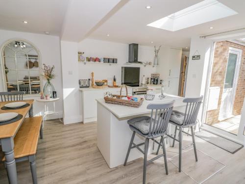 a kitchen and dining room with a table and chairs at Blossom Cottage in Broadway