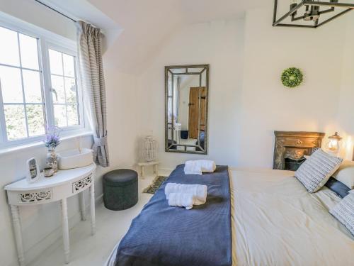 a bedroom with two beds and a sink and a mirror at Blossom Cottage in Broadway