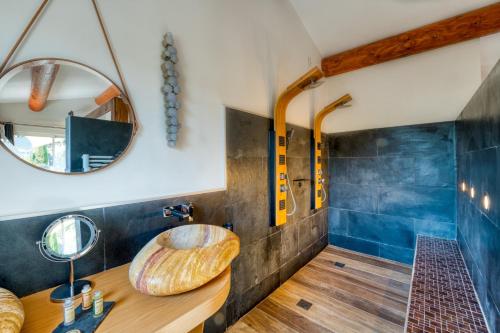 La salle de bains est pourvue d'une coiffeuse en bois et d'un miroir rond. dans l'établissement Mas des Cigales, à Eygalières