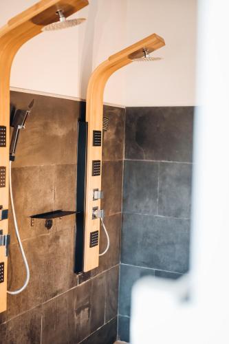 a bathroom with a shower and a tiled wall at Mas des Cigales in Eygalières