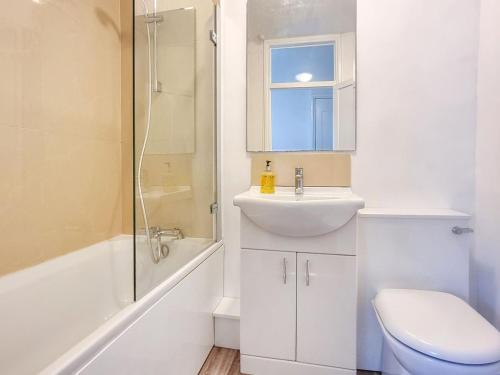 a bathroom with a sink and a toilet and a shower at Pear Tree Cottage in Bath