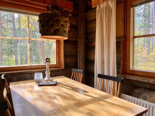 tavolo da pranzo con sedie e lampadario di Lapland Lodge Pyhä Ski in, sauna, free WiFi, national park - Lapland Villas a Pyhätunturi