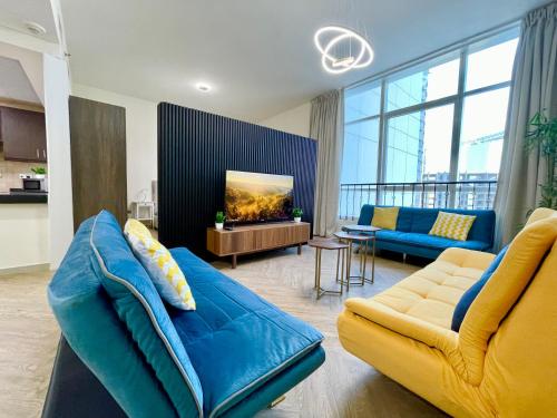 a living room with a blue couch and a tv at Elite Private Residential Apartment in a Prime Location Al Reem Island - 1301 in Abu Dhabi