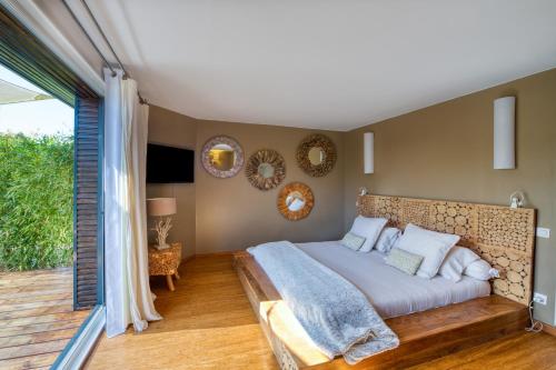 a bedroom with a large bed and a balcony at Mas des Cigales in Orgon
