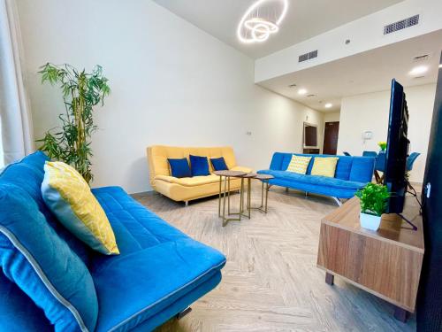 a living room with blue couches and a table at Elite Private Residential Apartment in a Prime Location Al Reem Island - 1301 in Abu Dhabi