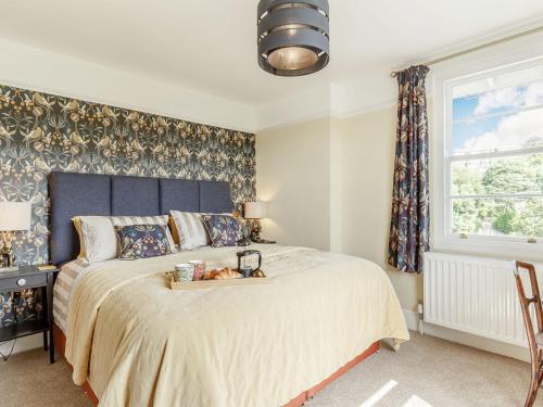 a bedroom with a large bed with a blue headboard at Cavern House in Torquay