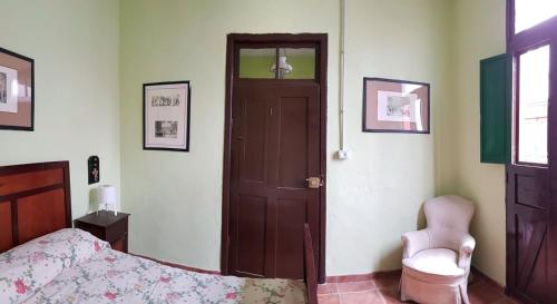 a bedroom with a bed and a door and a chair at I MITI ViviendaVacacional in Chio