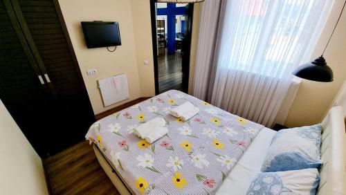 a small bedroom with a bed with flowers on it at Old BATUMI MGZAVREBI APARTMENTS in Batumi