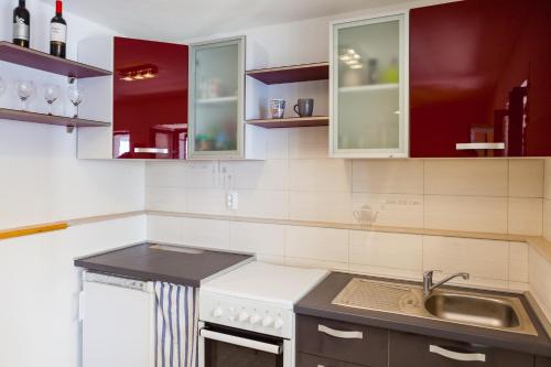 a kitchen with red cabinets and a sink at The Captain's Nook Spiliska in Blato