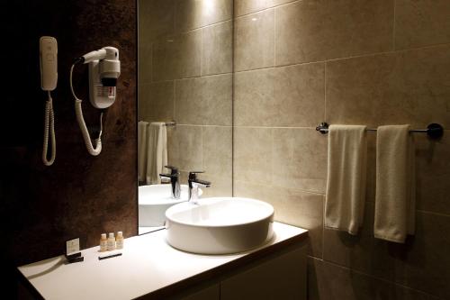 bagno con lavandino e telefono appeso al muro di Carina Park Suites Nisantasi a Istanbul