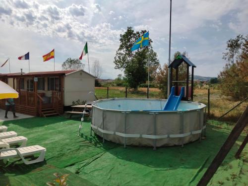 una piscina en un patio con banderas en el fondo en VILLAGGIO degli ANGELI SCERNE PINETO, en Scerne