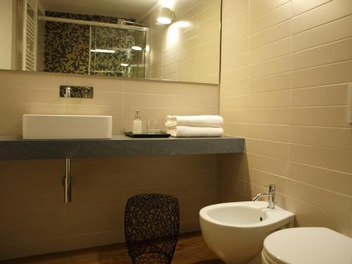 a bathroom with a sink and a toilet and a mirror at Luxury Apartments Manarola by Arbaspàa in Manarola