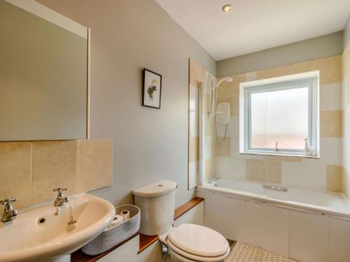 a bathroom with a toilet and a sink and a tub at Courtyard Cottage - Uk39179 in Rossendale