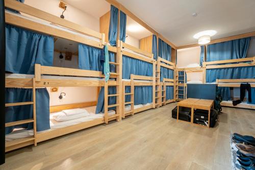 a room with four bunk beds with blue curtains at GARDEN - Utopy Hostel in Biarritz