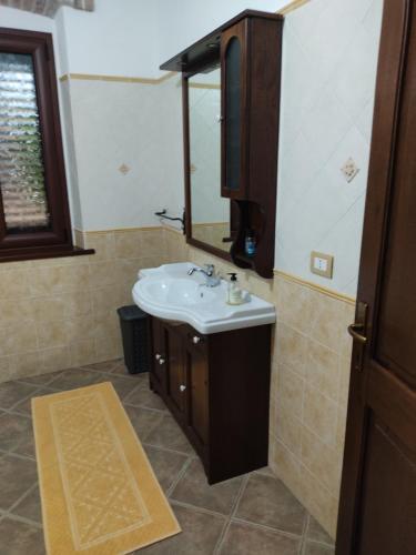 y baño con lavabo y espejo. en Casa di Stefano en Villamassargia