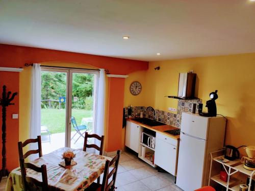 une cuisine avec une table et un réfrigérateur blanc dans l'établissement Villas en chanay, à Dagneux